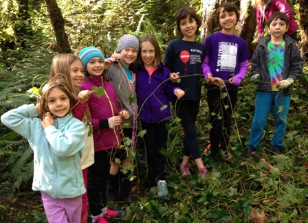 Eight young volunteers holding ivy vines